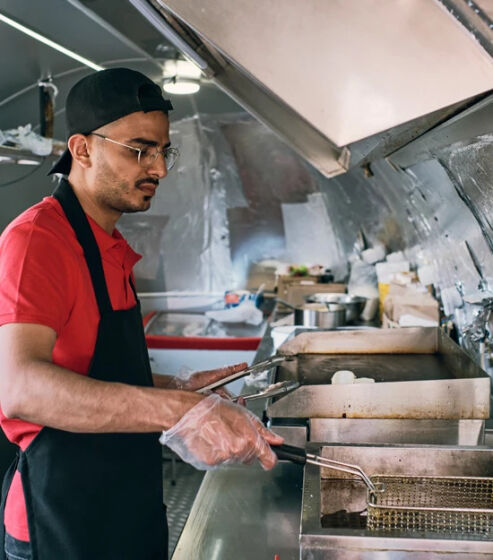 Medewerker gebruikt professionele frituur in een foodtruck