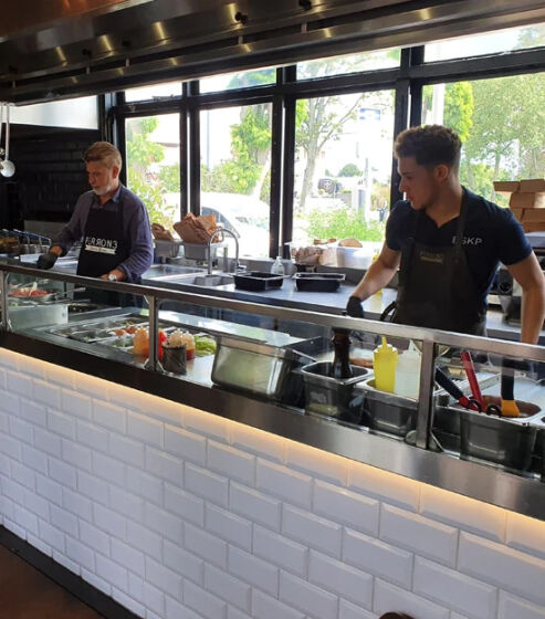 Medewerkers bereiden bestellingen in een professionele broodjeszaak